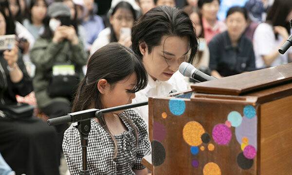 지난 28일&nbsp;서울 종로구 서울문화재단 대학로센터 야외 마당에서 피아니스트 이나우(오른쪽)가 초등학생 조서연 양과 거리에 설치될 피아노에서 연주하는 모습. 서울문화재단 제공