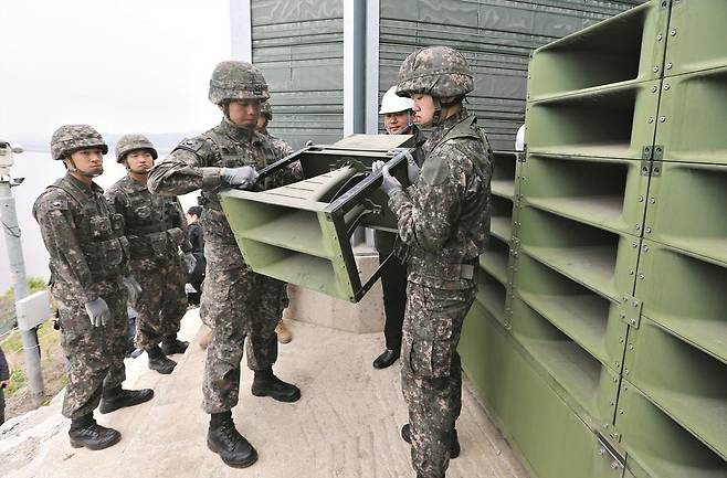 2018년 5월 1일 오후 경기도 파주 육군 9사단 교하소초에서 병사들이 임진강변에 설치된 대북 심리전 확성기 방송시설을 철거하고 있다.