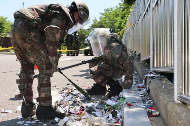 Soldiers point a mine detector at the remains of a North Korean filthy balloon that fell in front of the Incheon Air Defense Center in Jung-gu, Incheon, South Korea, on Nov. 2. Yonhap