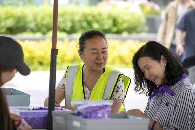 5월22일 이태원 참사 분향소에서 봉사활동을 하는 김미경씨(형광색 조끼)가 지킴이 유가족들과 이야기를 나누며 리본을 만들고 있다. ⓒ시사IN 신선영