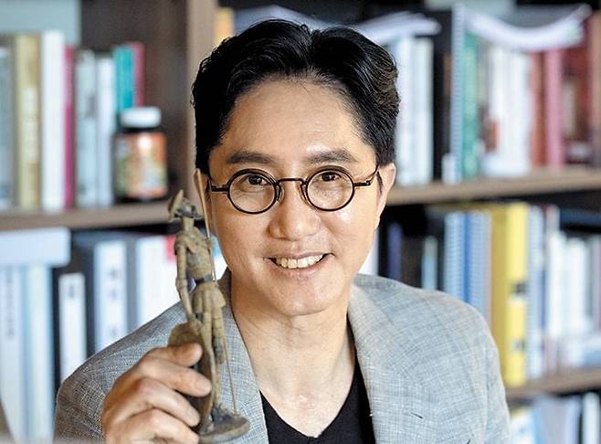 세 번 실패에도 또 도전하자, 그에겐 ‘뮤지컬 돈키호테’라는 별명이 붙었다. 서울 청담동 사무실에서 오디컴퍼니 뮤지컬 ‘맨 오브 라만차’의 돈키호테 모형을 들어 보이는 신춘수 대표. /박상훈 기자