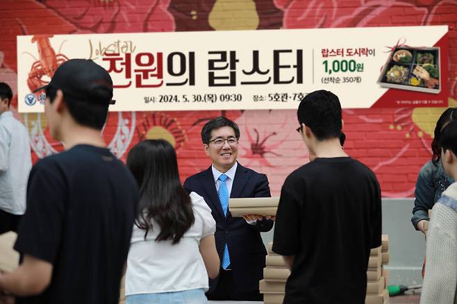 김현중 유한대학교 총장이 '천원의 랍스터' 이벤트에서 학생들에게 랍스터 특식 도시락을 나눠주고 있다./사진제공=유한대