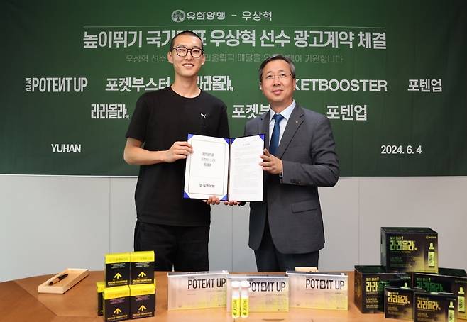 왼쪽부터 국가대표 우상혁과 홍현동 유한양행 약국사업부장 상무가 광고계약 체결 후 기념 촬영하고 있다./사진= 유한양행