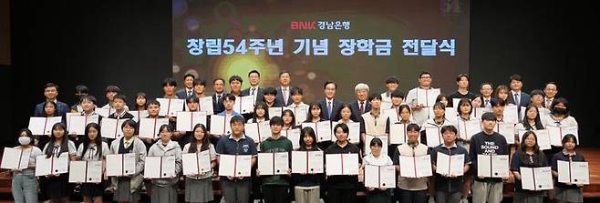 BNK경남은행의 창립 54주년 기념 장학금 전달식에 참가한 임직원과 학생들이 기념촬영을 하고 있다.ⓒBNK경남은행