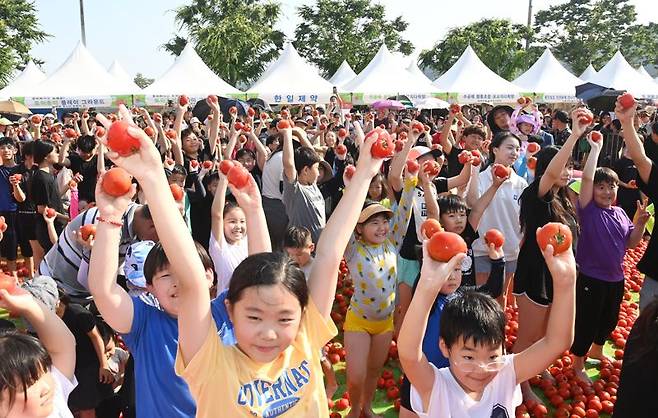 경기 광주시 '퇴촌 토마토축제'가 오는 14~16일 개최된다. 토마토를 손에 쥔 참가자들이 축제를 즐기고 있다. 경기 광주시 제공