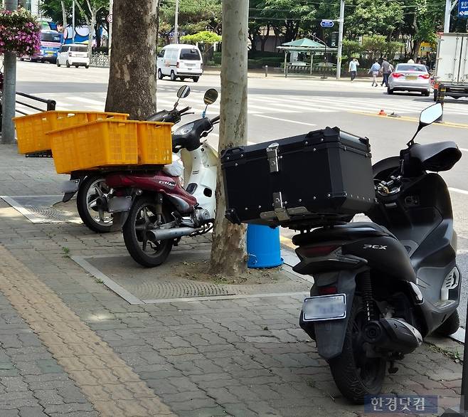 한 가게 앞에 세워져 있는 배달용 오토바이 / 사진=성진우 기자