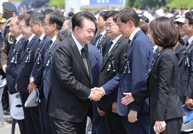 제69회 현충일인 6일 서울 동작구 국립서울현충원에서 열린 추념식을 마친 윤석열 대통령이 조국 조국혁신당 대표와 악수하고 있다. 김지훈 기자