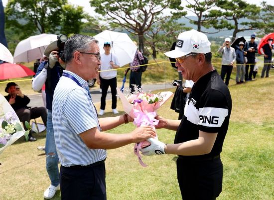 최상호(오른쪽)가 제67회 KPGA 선수권에서 2라운드를 마친 뒤 김원섭 KPGA 회장으로부터 꽃다발을 받고 있다.[사진제공=KPGA]