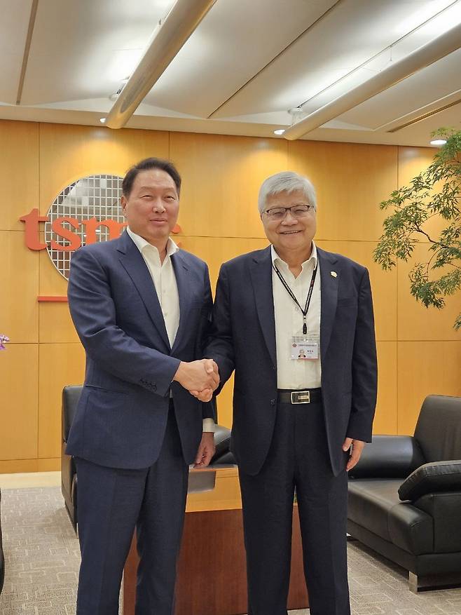 SK Chairman Chey Taewon, left, and TSMC Chairman C.C. Wei shake hands on Thursday at the TSMC's headquarters in Taipei. [SK]