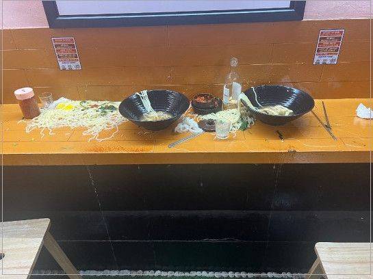 우동집을 방문한 남녀 커플이 육수를 늦게 갖다 준다는 이유로 우동 두 그릇을 그대로 테이블에 쏟아버린 모습. [아프니까 사장이다]