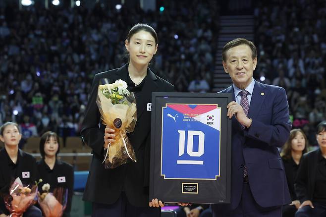 ▲ 김연경이 8일 서울 잠실 실내체육관에서 열린 국가대표 은퇴식에서 기념 액자를 들고 촬영에 나서고 있다. 오른쪽은 오한남 대한배구협회장이다. 김연경은 지난 2020 도쿄올림픽 4강 신화를 이끌고 국가대표 은퇴를 선언했다.