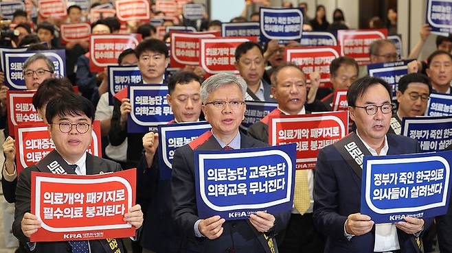 서울 용산구 대한의사협회에서 열린 전국의사대표자대회에서 임현택 대한의사협회 회장(왼쪽), 김택우 전 대한의사협회 비상대책위원장(가운데) 등 참석자들이 구호를 외치고 있다.