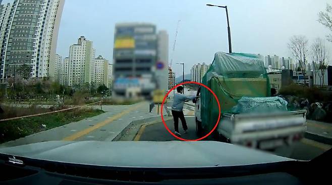 지난 4월 10일 오후 2시 50분께 경기 광주시 태전동 일대 한 비탈길에서 사이드가 풀린 채 굴러가는 트럭을 이희성씨가 멈춰 세우고 있다.(사진=경기남부경찰청)