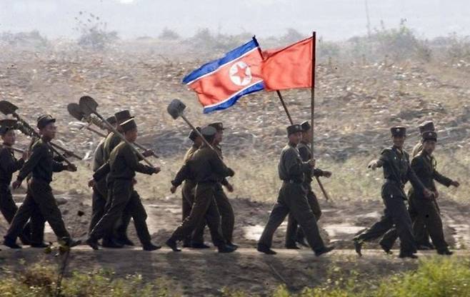 북한군 병사들이 삽과 인공기를 들고 신의주 외곽을 행진하고 있다. 사진=자유아시아방송(RFA) 홈페이지 캡처