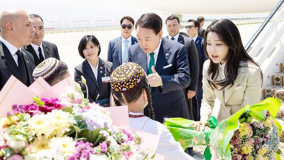 윤석열 대통령과 김건희 여사가 10일 오후(현지시간) 투르크메니스탄 아시가바트 공항에 도착해 투르크메니스탄 전통 의상을 입은 화동들이 준비한 환영 빵과 꽃다발을 받고 있다. 연합뉴스