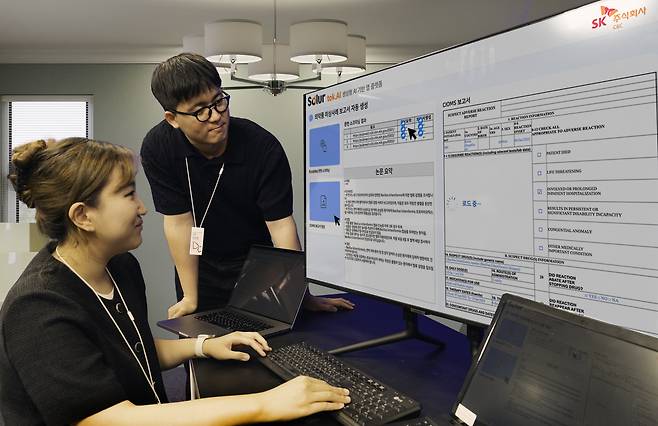 SK C&C 구성원들이 엔터프라이즈 AI 솔루션 ‘솔루어(Solur)’를 활용한 ‘생성형 AI 의약품 이상사례 보고서’ 데모 버전을 시연하고 있는 모습. [SK C&C 제공]