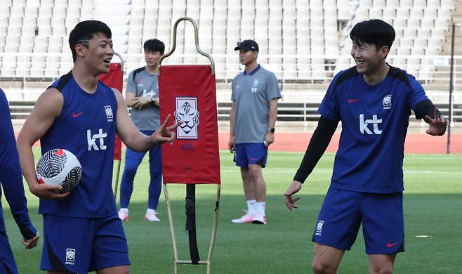 축구대표팀 손흥민(오른쪽)과 황희찬이 9일 고양종합운동장에서 중국전을 이틀 앞두고 훈련 중 밝은 표정으로 이야기 하고 있다. 연합뉴스