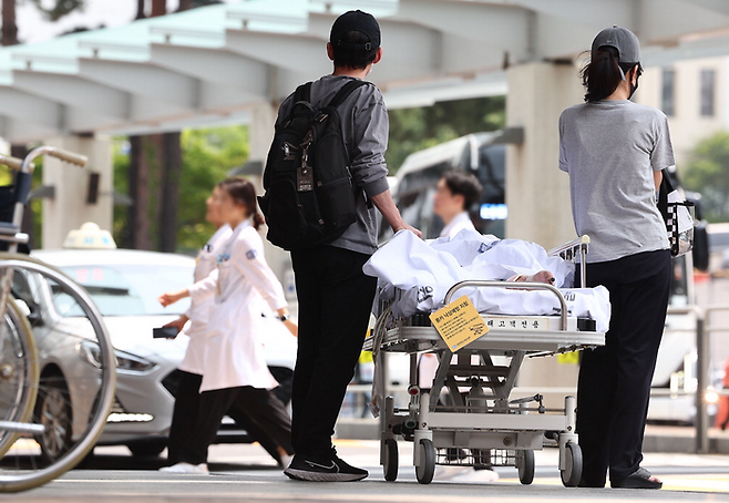 대한의사협회와 의대 교수 단체가 오는 18일 집단휴진을 선언한 가운데 10일 서울의 한 대학병원에서 환자 보호자들이 지나가는 의료진을 바라보고 있다. [사진 = 연합뉴스]