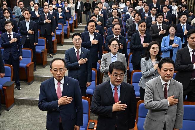 추경호 원내대표를 비롯한 국민의힘 의원들이 11일 서울 여의도 국회에서 열린 의원총회에 참석해 국민의례를 하고 있다.  한주형 기자