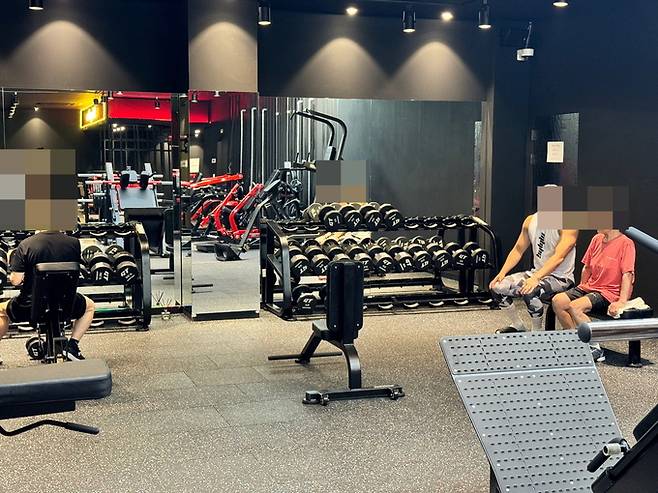 헬스 코치의 지도를 받으며 운동하는 중년 회원들 모습.