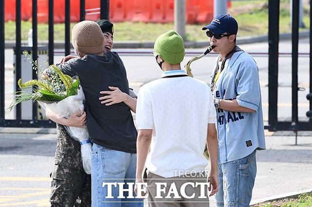 그룹 방탄소년단(BTS)의 진이 12일 오전 경기 연천 제5보병사단 신병교육대에서 전역하며 멤버들과 인사를 나누고 있다. 진과 포옹하는 멤버는 뷔. /연천=서예원 기자