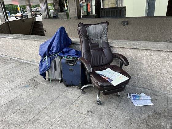 12일 오후 서울 중구 서울역 출구 앞에 지난 6일 흉기에 찔려 사망한 노숙인 조성준(가명·63)씨의 의자와 캐리어 2개가 덩그러니 남아있다. 장서윤 기자