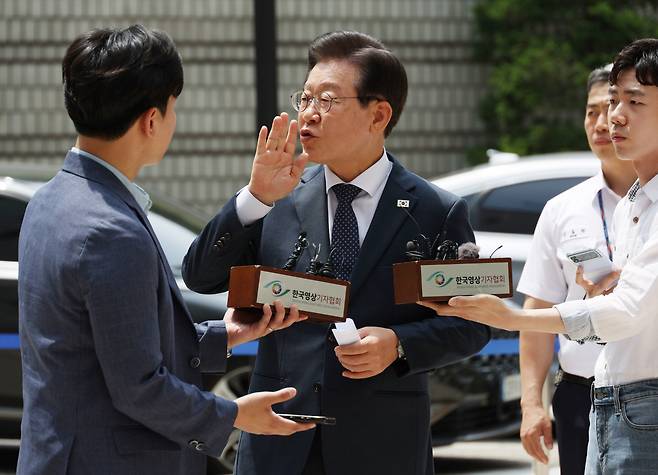 이재명(가운데) 더불어민주당 대표가 14일 서울 서초동 서울중앙지법에서 열리는 공직선거법 관련 재판에 출석하기에 앞서 취재진 앞에서 입장을 말하던 중 사람들을 향해 조용히 해줄 것을 요청하고 있다. [연합]