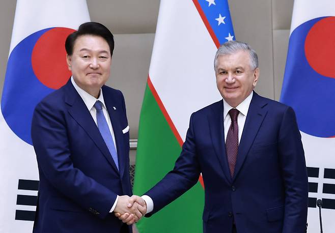 우즈베키스탄을 국빈 방문 중인 윤석열 대통령이 14일(현지시간) 우즈베키스탄 타슈켄트 대통령궁 영빈관에서 샤브카트 미르지요예프 우즈베키스탄 대통령과 한·우즈베키스탄 공동언론발표를 마치고 웃으며 악수하고 있다. [연합]