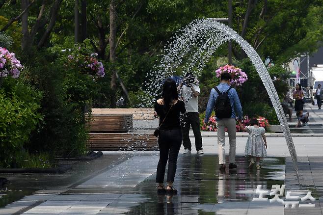 대구 등 영남 8개 지역에 올여름 첫 '폭염주의보가'가 발령되는 등 전국적으로 30도 안팎의 더위가 나타난 10일 서울 광화문광장을 지나던 시민들이 분수터널에서 잠시 더위를 식히고 있다. 박종민 기자