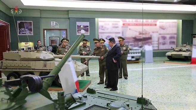 김정은 북한 국무위원장이 지난달 29일 국방과학원 전시관을 찾아 군 관계자들과 함께 대구경 주포 탑재 장갑차를 살피고 있다. 조선중앙TV 캡쳐