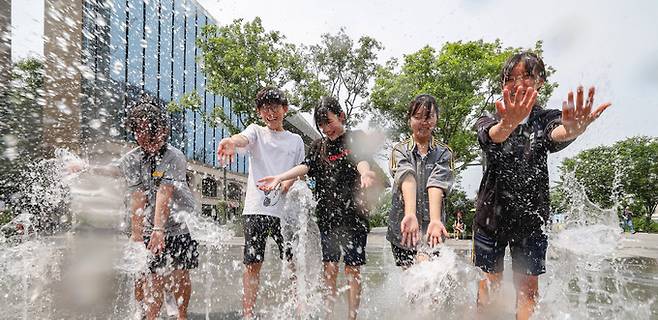 전국이 대체로 맑은 가운데 최고 기온 35도의 무더위를 기록한 14일 서울 종로구 광화문광장 분수대에서 중학생들이 물장난을 치며 즐거운 시간을 보내고 있다.