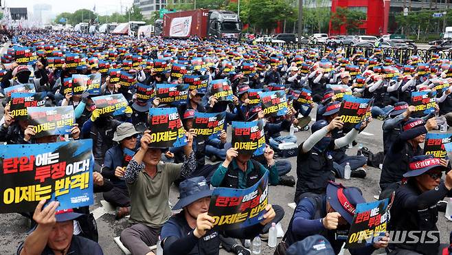 [서울=뉴시스] 추상철 기자 = 15일 오후 서울 영등포구 여의도공원 앞에서 열린 민주노총 공공운수노조 화물연대본부의 '화물노동자 총력투쟁 결의대회'에서 노조원들이 구호를 외치고 있다. 2024.06.15. scchoo@newsis.com