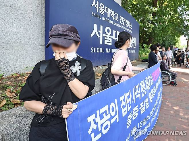 무기한 휴진 중단 촉구하며 울먹이는 환자  12일 오전 서울 종로구 서울대학교병원 앞에서 열린 한국중증질환연합회 주최 휴진 중단 촉구 기자회견에 참석한 한 암 환자가 눈물을 흘리고 있다. [연합뉴스 자료사진]