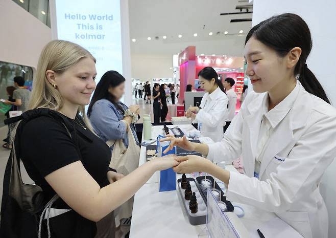 서울 중구 동대문디자인플라자에서 한 관람객이 화장품을 테스트하고 있다. (사진=연합뉴스)
