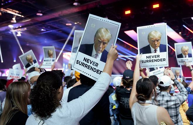 Attendees hold up ‘Never Surrender’ posters as Republican presidential candidate Donald Trump speaks at an event held by the national conservative political movement, “Turning Point”, in Detroit, Michigan, U.S., June 15, 2024. REUTERS/Rebecca cook