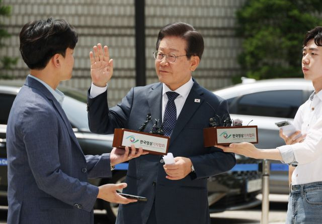 더불어민주당 이재명 대표가 지난 14일 서울중앙지법에서 열리는 공직선거법 관련 재판에 출석하기에 앞서 취재진 앞에서 입장을 말하던 중 사람들을 향해 조용히 해줄 것을 요청하고 있다. 연합뉴스