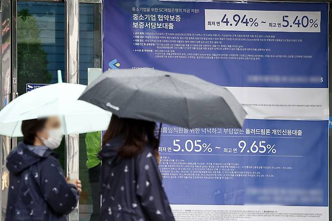 서울 한 시중은행 영업점의 대출 안내문 앞을 시민이 지나가고 있다.[연합]