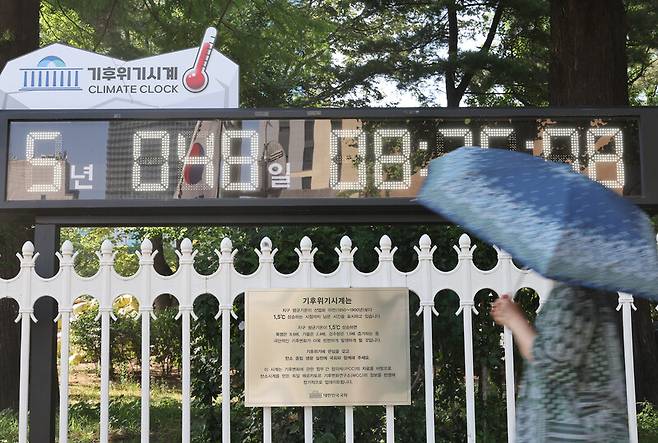 세계 환경의 날을 하루 앞둔 지난 4일 서울 여의도 국회 앞에서 한 시민이 기후위기시계를 바라보고 있다. 연합뉴스
