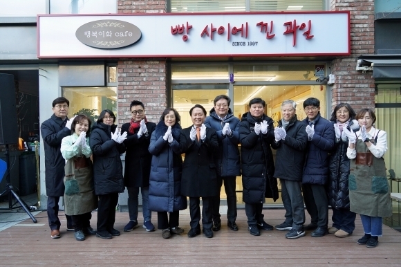 지난해 12월 서울 서대문구 이화여대 앞 상가 골목에서 열린 행복이화 카페 ‘빵 사이에 낀 과일’ 개업식에서 이성헌(왼쪽 여섯 번째) 서대문구청장이 주민들과 기념 촬영을 하고 있다. 서대문구 제공