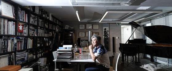 홍태선 건축가. 그의 집무실은 그가 사랑하는 것들의 집합체다. 피아노부터 건축 관련 자료, 와인이 빼곡하다. 김경록 기자