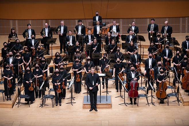 Vasily Petrenko (center), the music director of the Royal Philharmonic Orchestra, and the members of the Seoul Philharmonic Orchestra greet the audience after a performance in Seoul on April 21, 2022. (SPO)