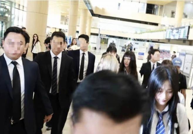 뉴진스가 경호원과 함께 김포공항 출국장에 들어서고 있다/사진=온라인 커뮤니티 갈무리