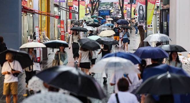 비가 내린 22일 오전 서울 명동거리에 시민들과 관광객들이 우산을 쓰고 이동하고 있다, (사진=연합뉴스)