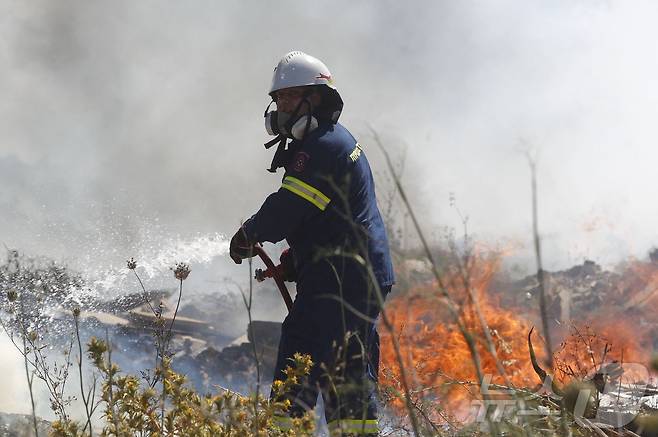 19일(현지시간) 그리스 아테네 외곽 도시 킫시에서 소방관이 산불을 진압하고 있다. 2024.06.19. ⓒ AFP=뉴스1 ⓒ News1 김민재 기자