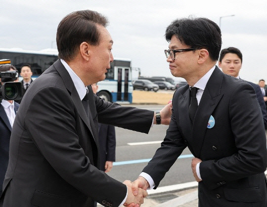 윤석열 대통령이 지난달 22일 경기도 평택 해군 제2함대사령부에서 거행된 제9회 서해수호의날 기념식 행사를 마친 뒤 국민의힘 한동훈 비상대책위원장의 어깨를 두드려 주며 악수하고 있다. 연합뉴스.