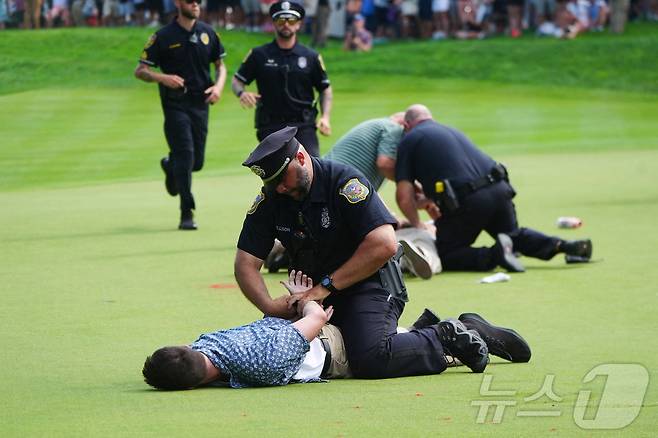 24일(한국시간) 열린 PGA투어 트래블러스 챔피언십 도중 코스에 난입한 시위대를 경찰이 진압하고 있다. ⓒ 로이터=뉴스1