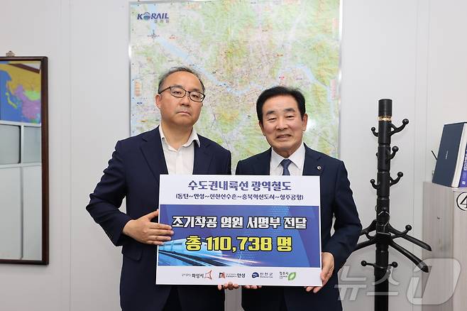 송기섭 진천군수(오른쪽)가 24일 국토교통부를 찾아 '수도권내륙선 광역철도 조기 착공' 범국민 서명부를 전달했다.(진천군 제공)/뉴스1