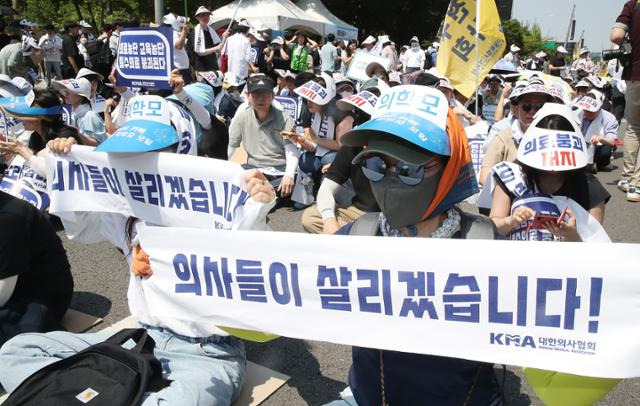 18일 서울 영등포구 여의도 환승센터 인근에서 열린 대한의사협회 전국 의사 총궐기대회에서 참석자들이 정부의 의대 증원 철회를 촉구하고 있다. 이 자리엔 의대생 학부모들도 참석했다. 뉴스1