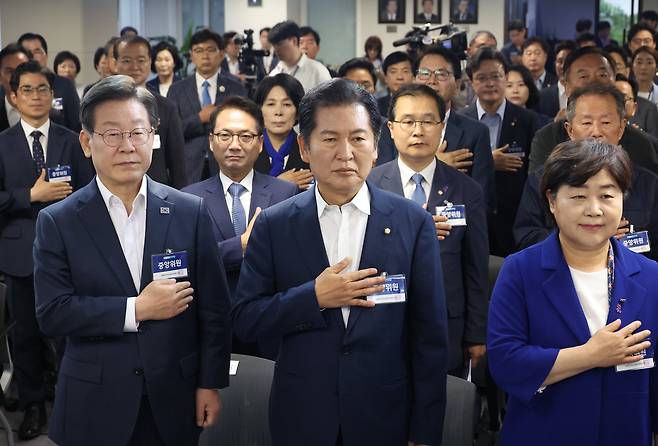 더불어민주당 이재명 대표가 6월17일 여의도 당사에서 열린 중앙위원회의에서 국기를 향해 경례하고 있다. 민주당은 이 회의에서 대선에 출마하려는 당 대표의 사퇴 시한에 예외를 둘 수 있도록 하는 내용의 당헌 개정을 시도했다. ⓒ연합뉴스