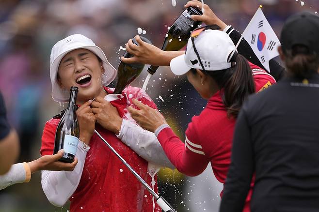 양희영이 24일 미국 워싱턴주 서매미시의 사할리CC에서 열린 LPGA 투어 시즌 3번째 메이저대회 KPMG 위민스 PGA 챔피언십 최종라운드에서 생애 첫 메이저 우승컵을 든 뒤 동료선수들의 샴페인 세례에 행복해 하고 있다. 서매미시｜AP연합뉴스